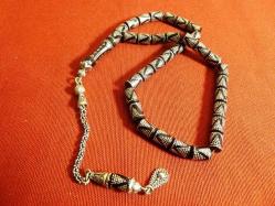 Gümüş püsküllü, gümüş işlemeli, usta işi ateş kehribar 33'lük tesbih. Püskül dahil 29cm.