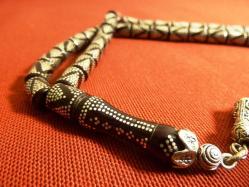 Gümüş püsküllü, gümüş işlemeli, usta işi ateş kehribar 33'lük tesbih. Püskül dahil 29cm.