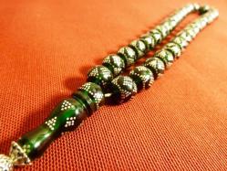 Gümüş püsküllü, gümüş işlemeli, usta işi yeşil ateş kehribar 33'lük tesbih. Püskül dahil 38cm.