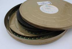 Makaralı Film Makinesi ve dört adet kutusunda filmler. Makine 29 x 24 cm.ölçülerinde ki  özel çantasında,  filmler 38 cm. Çapında özel teneke ve plastik kutularında.