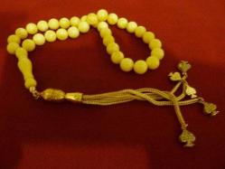 Sıkma kehribar,  altın renkli püsküllü 33'lük tesbih. İmame dahil 20cm.