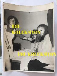 EFSANE MÜZİK GRUBU BEYAZ KELEBEKLER'İN ÇOK NADİR BİR ORİJİNAL FOTOĞRAFI, 24 x 18 cm EBADINDA, SİYAH & BEYAZ - BEYAZ KELEBEKLER'İN SOLİSTİ ÜLKÜ ÜST'ÜN KAZADAN SONRA HASTANEDE TEDAVİ EDİLİRKEN ÇEKİLMİŞ BÜYÜK BOY BİR FOTOĞRAFI, 1970