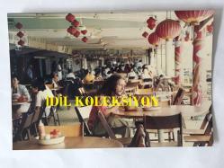 BARIŞ MANÇO'NUN ORİJİNAL FOTOĞRAFI - 17 x 12 cm EBADINDA - BARIŞ MANÇO, 7'DEN 77'YE PROGRAMINDA MALEZYA'NIN ESKİ ŞEHİRLERİNDEN TİCARİ MERKEZİ MALAKA ŞEHRİNDE BİR KAFEDE TROPİKAL BİR MEYVENİN SUYUNU İÇERKEN BİR KARE, 1990'LAR, AGFA Orijinal Alman Baskı