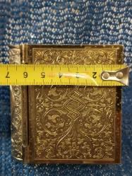 KİTAP FORMUNDA YAPILMIŞ SEDEF KADRANLI PİRİNÇ ANTİKA KURMALI MASA SAATİ 1940-50 lerden Alman yapımı kitap formunda antika kurmalı masa saati. Bakımları yapılmış çalışır vaziyette.  Boyut: 7,5x7x3cm