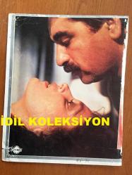 İBRAHİM TATLISES'İN KARTONA BASILMIŞ BİR FOTOĞRAFI - İBRAHİM TATLISES'İN NECLA NAZIR İLE ''YIKILMIŞIM BEN'' ADLI FİLMİN BİR SAHNESİNDE BİRBİRLERİYLE DUYGU DOLU GÖZLERLE BAKIŞTIKLARI ANLARDAN BİR KARE - 24 x 19 cm EBADINDA