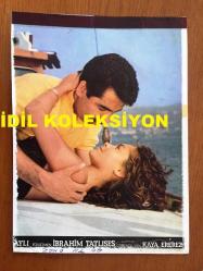 İBRAHİM TATLISES'İN KARTONA BASILMIŞ BİR FOTOĞRAFI - İBRAHİM TATLISES'İN HÜLYA AVŞAR İLE ''AYŞEM'' (1984) ADLI FİLMİNDEN BİRBİRLERİNE SAHİLDE SARILDIKLARI ANLARDAN BİR KARE - 23 x 17 cm EBADINDA