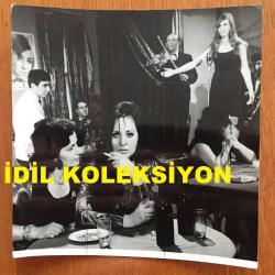 YEŞİLÇAM'IN YILDIZI SEVDA FERDAĞ'IN BÜYÜK BOY ORİJİNAL FOTOĞRAFI - 18 x 17 cm EBADINDA - SİYAH & BEYAZ - SEVDA FERDAĞ'IN BİR FİLM ÇEKİMLERİNDE GAZİNO MASASINDA İÇKİ İÇTİĞİ SAHNEDEN BİR KARE, DUVARDA GÖKBEN POSTERİ - 1970'LERDEN BİR FOTOĞRAF