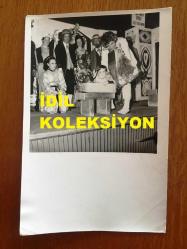 NEJAT UYGUR'UN ORİJİNAL FOTOĞRAFI - 18 x 12 cm EBADINDA - SİYAH & BEYAZ - NEJAT UYGUR'A SAHNEDE HEDİYE EDİLEN BAVULDAN ÇOCUK ÇIKARKEN ÇEKİLMİŞ GÜZEL BİR FOTOĞRAF