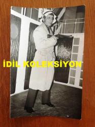 NEJAT UYGUR'UN ORİJİNAL 2'Lİ FOTOĞRAF SETİ - 18 x 12 cm EBADINDA 2 ADET FOTOĞRAF - SİYAH & BEYAZ - SİLAHLI GANGSTER ROLÜYLE TİYATRO SAHNESİNDE OYNAYAN NEJAT UYGUR ve EŞİ NECLA UYGUR'UN DA YER ALDIĞI 2 FARKLI KARE, 7 MART 1984
