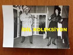 NEJAT UYGUR'UN ORİJİNAL 2'Lİ FOTOĞRAF SETİ - 18 x 12 cm EBADINDA 2 ADET FOTOĞRAF - SİYAH & BEYAZ - SİLAHLI GANGSTER ROLÜYLE TİYATRO SAHNESİNDE OYNAYAN NEJAT UYGUR ve EŞİ NECLA UYGUR'UN DA YER ALDIĞI 2 FARKLI KARE, 7 MART 1984