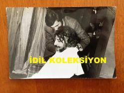 NEJAT UYGUR'UN ORİJİNAL 2'Lİ FOTOĞRAF SETİ - 18 x 12 cm ve 14 x 12 cm EBADINDA 2 ADET FOTOĞRAF - SİYAH & BEYAZ - NEJAT UYGUR SEYİRCİLERİN ÖNÜNDE MERASİMLE SAKALINI TRAŞ ETTİRİRKEN ÇEKİLMİŞ 2 FARKLI KARE, 24 NİSAN 1974