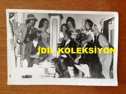 NEJAT UYGUR'UN ORİJİNAL 2'Lİ FOTOĞRAF SETİ - 18 x 12 cm EBADINDA 2 ADET FOTOĞRAF - SİYAH & BEYAZ - NEJAT UYGUR KOVBOY KIYAFETLERİ GİYİNMİŞ ŞEKLİDE EŞİ NECLA UYGUR ve DİĞER TİYATRO ARKADAŞLARIYLA BİRLİKTE AYNI KAREDE