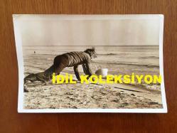 NEJAT UYGUR'UN ORİJİNAL 2'Lİ FOTOĞRAF SETİ - 18 x 12 cm ve 14 x 12 cm EBADINDA 2 ADET FOTOĞRAF - SİYAH & BEYAZ - NEJAT UYGUR KUMSALDA BAŞINDA BARET ve İŞÇİ KIYAFETİYLE SPOR YAPARKEN ve RÖPORTAJ VERİRKEN ÇEKİLMİŞ 2 FARKLI KARE
