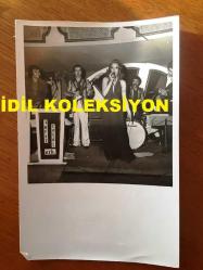 SES SANATÇISI RÜÇHAN ÇAMAY'IN ORİJİNAL 2'Lİ FOTOĞRAF SETİ - 18 x 12 cm EBADINDA - SİYAH & BEYAZ - RÜÇHAN ÇAMAY SAHNEDE ŞARKI SÖYLERKEN ÇEKİLMİŞ 2 FARKLI KARE, TURGUT DEMİRAĞ, SADRİ ALIŞIK ve ÇOLPAN İLHAN DİNLEYİCİLER ARASINDA