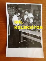 MİLLİ GİTARİST YURDAER DOĞULU'NUN ORİJİNAL FOTOĞRAFI - 18 x 12 cm EBADINDA - SİYAH & BEYAZ - YURDAER DOĞULU SES KAYIT BANTLARINI İNCELERKEN ÇEKİLMİŞ BİR FOTOĞRAF