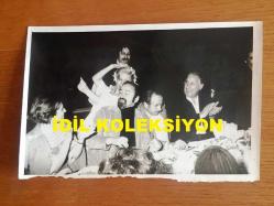 EMEL SAYIN'IN ORİJİNAL FOTOĞRAFI, 18 x 12 cm EBADINDA - SİYAH & BEYAZ - EMEL SAYIN SAHNE ALDIĞI MEKANDA KONUKLARIN MASASINA DOĞRU DANS EDERKEN ÇEKİLMİŞ BİR KARE