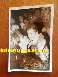 EMEL SAYIN'IN ORİJİNAL 2'Lİ FOTOĞRAF SETİ, 18 x 12 cm EBADINDA - SİYAH & BEYAZ - EMEL SAYIN'IN 1980'LERDEKİ BİR KONSERDE DİNLEYİCİLERDEN BİR BEBEĞİ ALIP KUCAKLADIĞI GÜZEL ANLARDAN 2 FARKLI KARE