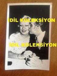 EMEL SAYIN'IN ORİJİNAL FOTOĞRAFI, 18 x 12 m EBADINDA - SİYAH & BEYAZ - EMEL SAYIN KENDİSİNİ YANAĞINDAN ÖPEN EŞİ İSMET KASAPOĞLU İLE BİRLİKTEYKEN ÇEKİLMİŞ ÇOK ÖZEL BİR KARE