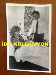 EMEL SAYIN'IN ORİJİNAL FOTOĞRAFI, 18 x 12 cm EBADINDA - SİYAH & BEYAZ - AŞIRI YORGUNLUKTAN TANSİYONU DÜŞEN EMEL SAYIN'IN NİŞANLISI DAVID YOUNNES YANINDA KENDİSİNE BAKARKEN ÇEKİLMİŞ BİR KARE, 23 NİSAN 1986