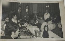 Özel bir davette yemek masasında oturup gülümseyerek poz veren bir grup erkek-kadın ve çocuk fotoğrafı.ORİJİNAL SİYAH & BEYAZ 14x 9cm EBADINDA - 1940'LAR, 1950'LER, 1960'LAR ve 1970'LER