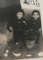 Bir bahçede önlerinde saksı ile gülümseyerek poz veren iki kücük çocuk fotoğrafı. Sevgili amcacığım şu cansız hayalimizi sizlere hatıra olarak gönderiyoruz-Kamuran,Ercan-Selamlar .ORJİNAL SİYAH & BEYAZ 13x7cm EBADINDA - 1940'LAR, 1950'LER, 1960'LAR ve 1970'LER