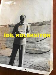 TÜRK HALK MÜZİĞİ SANATÇISI HASAN MUTLUCAN'IN ORİJİNAL BÜYÜK BOY FOTOĞRAFI - 24 x 18 cm EBADINDA - HASAN MUTLUCAN'IN AVRUPA GEZİSİ SIRASINDA İNGİLTERE'DE SAHİL KENARINDAKİ MANZARA ÖNÜNDE ÇEKTİRDİĞİ BİR HATIRA FOTOĞRAFI