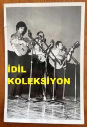 MODERN FOLK ÜÇLÜSÜ'NÜN ORİJİNAL FOTOĞRAFI - 18 x 12 cm EBADINDA - SELAMİ KARAİBRAHİMGİL, DOĞAN CANKU ve AHMET KURTARAN SAHNEDE GİTAR ÇALIP ŞARKI SÖYLERLERKEN ÇEKİLMİŞ BİR KARE