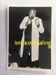 TANJU OKAN'IN ORİJİNAL FOTOĞRAFI - 12 x 8 cm EBADINDA - TANJU OKAN BEYAZ PALTOSUYLA SAHNEDE ŞARKI SÖYLERKEN ÇEKİLMİŞ BİR KARE, 15 ARALIK 1991