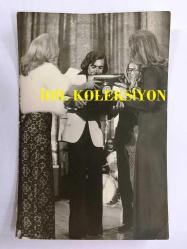 TANJU OKAN'IN ORİJİNAL FOTOĞRAFI - 18 x 12 cm EBADINDA - TANJU OKAN SAHNEDE KENDİSİNE VERİLEN ÖDÜLLERİ TAŞIMAKTA ZORLANIRKEN ÇEKİLMİŞ BİR FOTOĞRAF