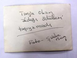 TANJU OKAN'IN ORİJİNAL FOTOĞRAFI - 18 x 12 cm EBADINDA - TANJU OKAN SAHNEDE KENDİSİNE VERİLEN ÖDÜLLERİ TAŞIMAKTA ZORLANIRKEN ÇEKİLMİŞ BİR FOTOĞRAF