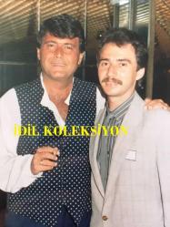 FERDİ ÖZBEĞEN'İN ORİJİNAL FOTOĞRAFI - 15 x 12,5 cm EBADINDA - FERDİ ÖZBEĞEN KAYBETTİĞİ ANA YADİGARI YÜZÜĞÜNÜ BULAN GENCE ALTINYUNUS'TA KİRALADIĞI VİLLAYI 3 YILLIĞINA KULLANMAK ÜZERE ÖDÜL OLARAK VERDİ, FERDİ ÖZBEĞEN ve O GENÇ AYNI KAREDE POZ VERİRKEN ÇEKİLMİŞ BİR FOTOĞRAF ve İLGİLİ HABER NOTUNUN YAZILI OLDUĞU KAĞIT