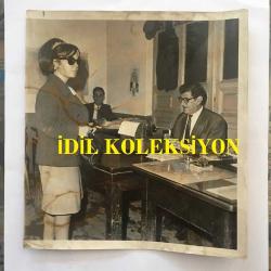 MUHTEREM NUR'UN ORİJİNAL BÜYÜK FOTOĞRAFI - 17 x 19 cm EBADINDA - NUHTEREM NUR 1966 YILINDA 10,000 LİRALIK BİR SENETİ ÖDEMEDİĞİ İDDİASI İLE UÇAKLA ANKARA'DAN İSTANBUL'A GELİRKEN POLİS NEZARETİNDE GÖTÜRÜLDÜ VE BİR GECE NEZARETTE YATTI. ERTESİ GÜN ADLİYEDE SAVCILIĞA İFADE VERDİ - MUHTEREM NUR İFADE VERİRKEN ÇEKİLMİŞ BİR FOTOĞRAF