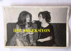 EMEL SAYIN'IN ORİJİNAL 2'Lİ FOTOĞRAF SETİ, 18 x 12 m EBADINDA - SİYAH & BEYAZ - EMEL SAYIN ŞARKICI OLMAK İSTEYEN KIZ KARDEŞİ FATOŞ SAYIN'A ''EV KADINI OL'' DİYE NASİHAT VERİRKEN ÇEKİLMİŞ BİR KARE, EMEL SAYIN SİYAH SAÇLARI İLE