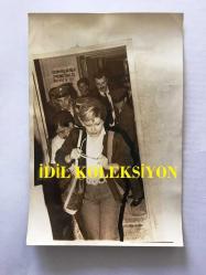 EMEL SAYIN'IN ORİJİNAL 2'Lİ FOTOĞRAF SETİ, 18 x 12 m EBADINDA - SİYAH & BEYAZ - EMEL SAYIN BİR KAMU DAİRESİNDEN HALKIN ve POLİSLERİN EŞLİĞİNDE ÇIKARKEN ÇEKİLMİŞ 2 FARKLI KARE, 1980'LER