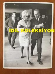 GÖNÜL YAZAR'IN ORİJİNAL BÜYÜK BOY FOTOĞRAFI - 24 x 18 cm EBADINDA - GÖNÜL YAZAR AÇIK RENK TAKIM ELBİSESİ ve GÜNEŞ GÖZLÜKLERİYLE KONUŞARAK YÜRÜRKEN ÇEKİLMİŞ BİR KARE