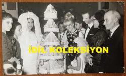 GÖNÜL YAZAR'IN ORİJİNAL BÜYÜK BOY 4'LÜ FOTOĞRAF SETİ - 24 x 18 cm, 22 x 14 cm ve 21 x 13 cm EBADINDA 4 ADET SİYAH & BEYAZ OTOĞRAF - GÖNÜL YAZAR 1960'LARDA KATILDIĞI BİR DÜĞÜNDE GELİN ve DAMATLA PASTA KESERKEN ve KONUKLARLA OTURURKEN ÇEKİLMİŞ 4 FARKLI HATIRA FOTOĞRAFI