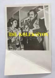 YILDIRIM GENCER'İN ORİJİNAL 2'Lİ FOTOĞRAF SETİ 18 x 12 cm EBADINDA - YILDIRIM GENCER ve ÜLKÜ ÖZEN BİRLİKTE ROL ALDIKLARI ''ŞAFAKTA SİLAH SESLERİ (1973'' İSİMLİ FİLM SONRASI ARMUT HEDİYE EDİLİRKEN ÇEKİLMİŞ 2 FARKLI KARE (ALİ BABA LOKANTASI TABELASI)