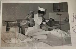 Yeni doğmuş olan bir bebeği giydirirken çekilmiş olan yetişkin bir hemşirenin fotoğrafı.ORJİNAL SİYAH & BEYAZ 17x12cm EBADINDA - 1940'LAR, 1950'LER, 1960'LAR ve 1970'LER