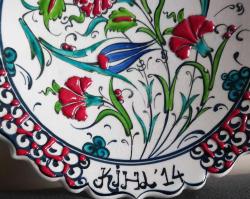 EL YAPIMI VE EL BOYAMASI ÇİNİ TABAK. BOGAZİÇİ EL SANATLARI YAZILI.  SANATÇI İSMİ ÜZERİNE İŞLENMİŞTİR.  LALE VE KARANFİL MOTİFLİ.