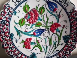 EL YAPIMI VE EL BOYAMASI ÇİNİ TABAK. BOGAZİÇİ EL SANATLARI YAZILI.  SANATÇI İSMİ ÜZERİNE İŞLENMİŞTİR.  LALE VE KARANFİL MOTİFLİ.