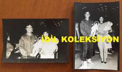 ŞARKICI NECO'NUN ORİJİNAL 2'Lİ FOTOĞRAF SETİ 18 x 12 cm EBADINDA - NECO, EŞİ OYA GERMEN'LE AVRUPA'DAN 15 GÜNLÜK TATİLDEN DÖNDÜKLERİNDE KUCAKLARINDA TUTTUKLARI 2 OYUNCAK BEBEKLE HAVA LİMANINDA POZ VERİRKEN ÇEKİLMİŞ 2 FARKLI KARE, 1984