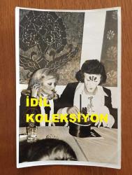 ŞARKICI NECO'NUN ORİJİNAL FOTOĞRAFI - 18 x 12 cm EBADINDA - YÜZÜNÜ BOYAYIP MASADAKİ ŞAPKADAN TAVŞAN ÇIKARAN NECO ve EŞİ OYA GERMEN AYNI KAREDE