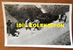 FİLİZ AKIN'IN ORİJİNAL FOTOĞRAFI - 18 x 12 cm EBADINDA - FİLİZ AKIN 1970'LERDE BİR YEŞİLÇAM FİLMİ SAHNESİNDE YOLDA OTOMOBİL YANINDA KAÇIRILIRKEN SET ARKASINDAN ÇEKİLMİŞ BİR KARE