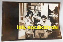Efemera - LEVENT KIRCA'NIN AJANS BASIMI ORİJİNAL FOTOĞRAFI - 18 x 12 cm EBADINDA - LEVENT KIRCA İLK EŞİ NUR DİNER ve OĞLU OĞULCAN KIRCA'NIN YANINDA SAZ ÇALARKEN ÇEKİLMİŞ BİR AİLE FOTOĞRAFI, 25 MART 1983 - kitantik - kitaLog