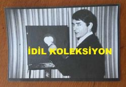 BESTECİ ve ŞARKICI ALPAY'IN ORİJİNAL AJANS BASIMI (KAĞIT BASKI) FOTOĞRAFI (Ahmet Alpay Nazikoğlu) - 18 x 12 cm EBADINDA - ALPAY PANODAKİ KALP İŞARETİNİ GÖSTERİRKEN