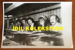 BEYAZ PERDENİN PRENSİ, YEŞİLÇAM'IN YILDIZ OYUNCUSU SALİH GÜNEY'İN ORİJİNAL 2'Lİ FOTOĞRAF SETİ - 18 x 12 cm EBADINDA - ''KAHRAMANLAR (1974)'' ADLI YEŞİLÇAM FİLMİNDE BİRLİKTE ROL ALAN SALİH GÜNEY, TUGAY TOKSÖZ, TANJU KOREL, YILMAZ KÖKSAL ve GÖNÜL HANCI BİR KEBAPÇININ OCAKBAŞINDA ŞİŞ KEBAPLARIN PİŞMESİNİ BEKLERKEN ve BÜRODAKİ MASANIN BAŞINDA HEP BİRLİKTE POZ VERİRKEN (MUHTEMELEN YAPIMCI ŞAHİN KOCAK'LA) ÇEKİLMİŞ 2 FARKLI KARE