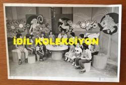 TİYATRO ve SESLENDİRME SANATÇISI PEKCAN KOŞAR'IN ORİJİNAL FOTOĞRAFI - 18 x 12 cm EBADINDA - PEKCAN KOŞAR BİR TELEVİZYON PROGRAMINDA ÇOCUKLARLA BİRLİKTE SÖYLEŞİ YAPARKEN