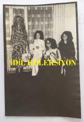 YEŞİLÇAM'IN DEĞERLİ OYUNCUSU HÜLYA TUĞLU'NUN AJANS BASIMI FOTOĞRAFI (KAĞIT BASKI) - 18 x 12 cm EBADINDA - HÜLYA TUĞLU ESKİŞEHİR'DE KONUK OLDUĞU BİR AİLEYE ÇEKİLİŞ YAPTIRIRKEN ÇEKİLMİŞ BİR KARE, 9 HAZİRAN1977