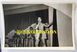 FERİ CANSEL'İN ORİJİNAL FOTOĞRAFI - 18 x 12 cm EBADINDA - FERİ CANSEL MİNİ ELBİSESİYLE SAHNEDE ŞARKI SÖYLERKEN ÇEKİLMİŞ BİR KARE