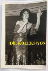 FERİ CANSEL'İN ORİJİNAL FOTOĞRAFI - 18 x 12 cm EBADINDA - FERİ CANSEL, ÇAKIL GAZİNOSU'NDA DEKOLTE ELBİSESİYLE SAHNEDE ŞARKI SÖYLERKEN ÇEKİLMİŞ BİR KARE